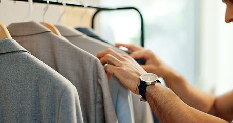 Image showing Man, suit and clothes rack in shop for search, check sale or decision on in shopping mall. Person, fabric and hands with choice, discount or thinking in retail customer experience in fashion boutique