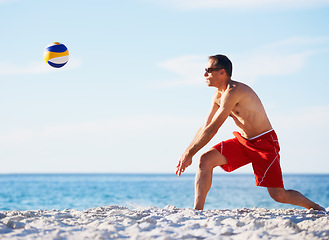 Image showing Sports, volleyball and man at beach with ball serve, energy or freedom on blue sky background. Ocean, fitness or male player with handball in nature for cardio, workout or athletic game performance