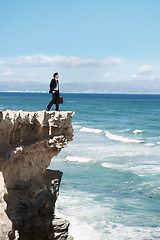 Image showing Thinking, cliff and business man by ocean for freedom, opportunity and career in nature. Professional, mockup and corporate worker on rocks edge for work challenge, ideas and future with scenic view