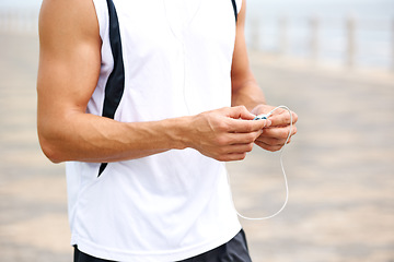 Image showing Man, workout and earphones to listen to music, podcast and song on run, exercise and cardio. Male athlete, hearing and streaming radio, audio and sound by ocean, outdoors and inspiration for fitness