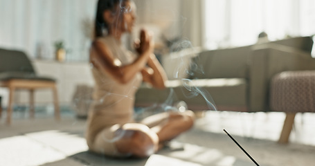 Image showing Woman, yoga and incense with lotus pose on living room floor for zen, mental health and wellness in house. Indian, person or breath with praying hands for chakra training, relax or home in meditation