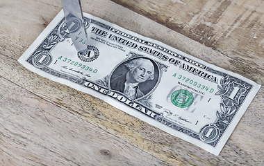 Image showing one American dollar pierced with a knife