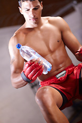 Image showing Boxing, man and bottle of water in gym for health, rest and energy from workout, fitness challenge and training for fight. Strong boxer drinking liquid for hydration, nutrition and power for exercise