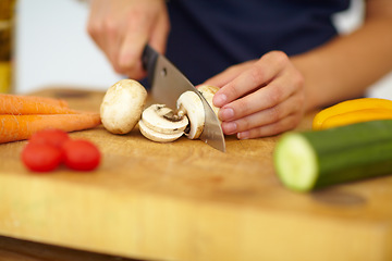 Image showing Chef hands, knife and vegetables on chopping board, cooking and preparation at home. Closeup of woman cutting mushrooms in kitchen, organic salad and food for healthy vegan diet, nutrition and dinner