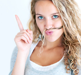 Image showing Woman, portrait and finger or hair mustache, fun confident humor or funny expression. Female person, face emoji or hands pointing on white wall background for playful, silly lips or meme in Canada