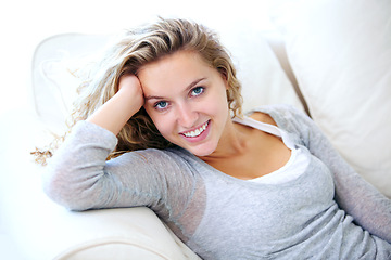 Image showing Woman, portrait and smile on couch for lazy relax weekend, comfortable day off or cosy. Female person, face and tranquility solitude pose on apartment sofa for calm, positive mood or break in Canada