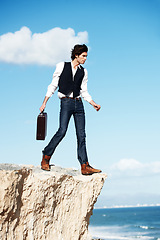 Image showing Businessman, thinking and standing on a cliff by the beach for adrenaline, adventure or a break in nature. Idea, walking and a worker or person on the edge of a rock or mountain at the ocean