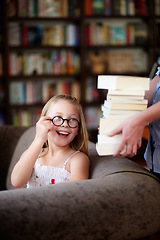 Image showing Smile, stack of books and happy child in library, learning and study homework knowledge on couch. School, woman and excited girl with glasses in bookstore together with story, and education on sofa.