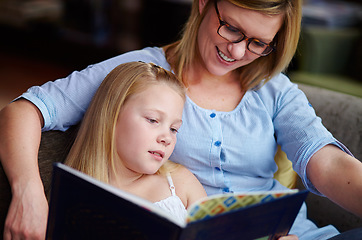 Image showing Reading, storytelling and mother with child in library with smile, learning and relax with study knowledge. Books, happy mom and girl on bookstore sofa together with story, fantasy and education.