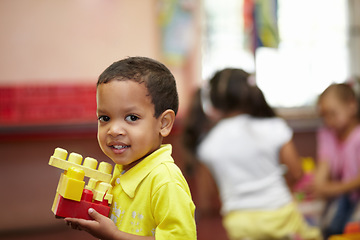 Image showing Boy, learning and building blocks in classroom for development, scholarship and thinking at kindergarten. Happy student child, plastic toys and smile for education at academy, school or idea in class