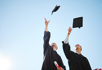 Image showing Graduation cap throw, blue sky and friends after a diploma, certificate and degree ceremony event. Education, university and school scholarship success of students happy about college achievement