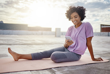 Image showing Phone, social media and yoga with a woman athlete on a rooftop for fitness, workout and exercise in the city. Sports, communication and training with a zen female exercising outside in the day