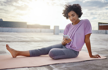 Image showing Phone, yoga and woman browsing on social media while sitting on a mat on workout break outdoor. Fitness, communication and girl athlete networking on the internet with smartphone while doing exercise