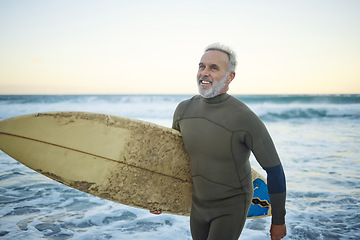 Image showing Water, happy and man surfing at the beach on a tropical holiday in Hawaii during sunrise in summer. Mature surfer with smile for the waves in ocean on vacation on an island for travel and adventure
