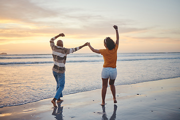 Image showing Love, travel and happy couple at beach enjoying summer vacation or fun honeymoon at sunset while holding hands and being playful. Laughing, energy and seaside holiday with black man and woman at sea