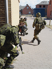 Image showing Army, soldier and training by building with weapon for fitness, exercise or challenge outdoor with gear. Military, people and running for workout, mission or bootcamp with camouflage for survival