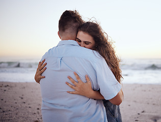 Image showing Love, hug and romance with a couple on the beach during a date on the sand by the sea or ocean at sunset. Summer, nature and travel with a young man and woman hugging on the coast while dating