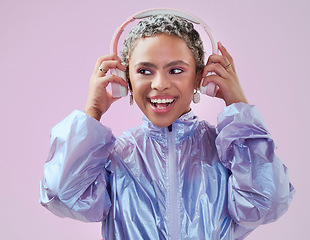 Image showing Black woman and holding headphones in studio for music streaming entertainment with pink wall. Mockup pink background with happy, funky and edgy african fashion girl enjoying bluetooth audio.