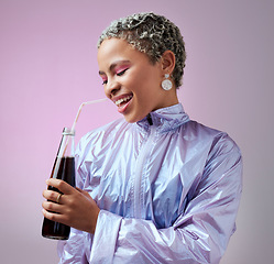 Image showing Smile, cola and woman with soda in studio drinking to hydrate and refresh with a cool beverage and straw in a bottle. Happy and young girl in fancy modern clothes enjoys a cold fizzy and tasty liquid