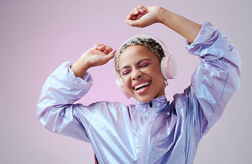 Image showing Dance, fashion woman and headphone listening to music and dancing against purple studio background. African american female smile, audio streaming and enjoy sound with a playful and freedom attitude