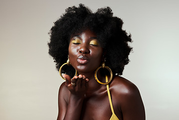 Image showing Black woman, beauty and retro fashion, afro hair and blow air kiss with gold makeup and jewelry on studio background. Portrait, gesture and face of female cosmetics model from Jamaica flirting inside