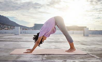 Image showing Yoga exercise, city rooftop and woman bending down for balance, wellness and health on an urban building in the morning. Fitness girl training and active during a healthy workout against overcast sky