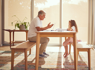 Image showing Girl homework, internet research and grandfather helping a kid with school work with books at a table in their house. Child writing and learning education in notebook with elderly person on laptop