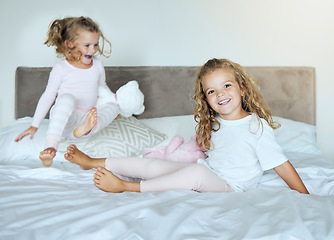 Image showing Happy, sisters and bed smile of little girls in playful joy and happiness together at home. Kids, sibling love and care for joyful relationship or friendship having fun in the bedroom