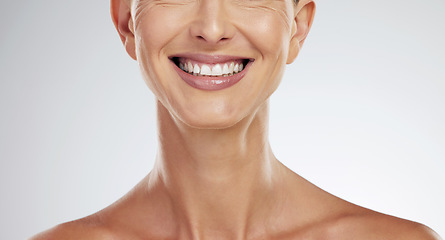 Image showing Teeth, face and mature woman beauty showing her natural looking dental veneers posing on gray studio background. Oral health, healthcare and model woman happy with tooth hygiene dental care closeup.