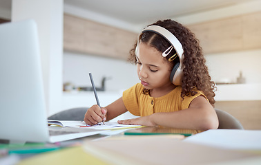 Image showing Children, education and writing with a girl student distance learning from home on a laptop for homework or study. Kids, book and school with a child at her desk to learn for growth and development