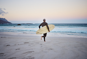 Image showing Surf at the beach, man and running to ocean with surfboard for the waves, fitness and adventure. Mature surfer at sunrise, in wet suit and to enjoy the sea, travel and summer on an island.