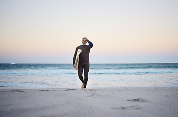 Image showing Man at the beach in summer, surf and adventure with the ocean in the background. Mature, surfer walking with surfboard and surfing for exercise and fitness on vacation after retirement.