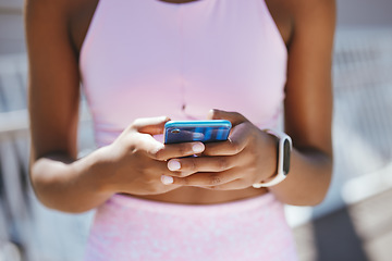 Image showing Hands, phone and black woman texting during workout outdoor, social media and internet browsing. Fitness, yoga and black girl reading online posts, checking message and taking a break from meditation