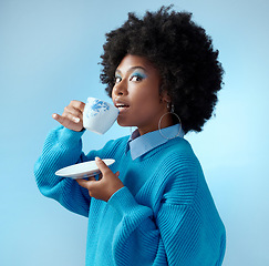 Image showing Afro hair, tea cup and black woman with fashion, style and trend clothes on blue background in studio with bold makeup cosmetics. Portrait, gossip and beauty model with wow or surprise face and drink