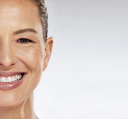 Image showing Half face, skincare and mature woman with smile for facial wellness in retirement against grey mockup studio background. Elderly model with beauty and skin health from dermatology with mock up space