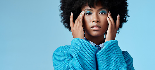 Image showing Blue makeup, fashion and beauty with a black woman in studio against a wall background with mockup. Cosmetics, face and eye shadow with a young female posing for contemporary or edgy style