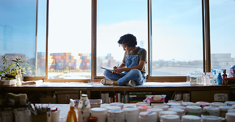 Image showing Woman artist in studio, drawing for art inspiration for painting new project for exhibition. Young creative Indian painter working in her workshop, focus on creativity and paint around her.