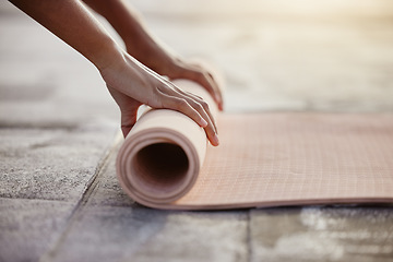 Image showing Macro of yoga, floor and woman hands with mat after exercise in gym, home or patio. Girl roll up gear after training, workout and fitness in stretching, breathe and mindfulness practice outside