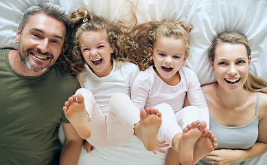 Image showing Top view, happy and family with twins in bed smiling together with parents in the morning at home on the weekend. Kids, smile and playful girls enjoy quality time with mother and father on Sunday