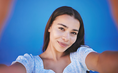 Image showing Smile, happy and taking selfie with woman showing face during travel against blue background. Pov portrait of smiling female with natural beauty taking a photo and having fun for social media