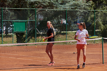 Image showing Tennis players standing together on the tennis court, poised and focused, preparing for the start of their match