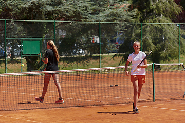 Image showing Tennis players standing together on the tennis court, poised and focused, preparing for the start of their match