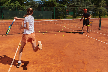 Image showing A professional tennis player and her coach training on a sunny day at the tennis court. Training and preparation of a professional tennis player