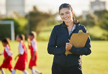 Image showing Soccer field, woman coach with and girl team training on grass in background. Sports, youth development and teamwork, a happy young female volunteer coaching football team with clipboard from Brazil.