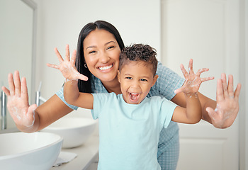 Image showing Mother and son in bathroom with clean hands, open palms that are cleaned and covered in foam teaching child hand washing. Cheerful parent help kid with hygiene for hand with water, soap and bubbles.