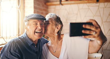 Image showing Love, phone and selfie with elderly couple kiss and relax in their home together, laughing and bonding. Photography, retirement and seniors enjoying retired lifestyle and romance in their living room