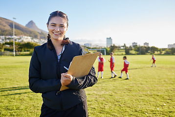 Image showing Football coach, junior sports and woman with clipboard coaching children on a soccer field or pitch outside on a sunny day. Happy female pe trainer outside for practice, training and exercise class