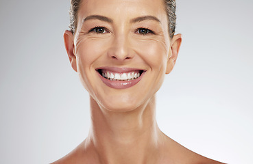 Image showing Face, portrait and skincare for mature woman with smile for facial health against a grey mockup studio background. Elderly model happy about natural wellness and dermatology with mock up space