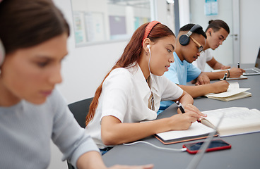 Image showing University, headphones and students writing notes while listening to music, educational podcast or radio audio. Earphones, college and group learning, studying or exam preparation with phone on desk.