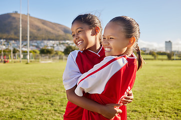 Image showing Football, girl and sports children hug, smile and happy together having fun, bond and enjoy outdoor game. Friends, young kids or teammates embrace on Brazil soccer field for youth academy training